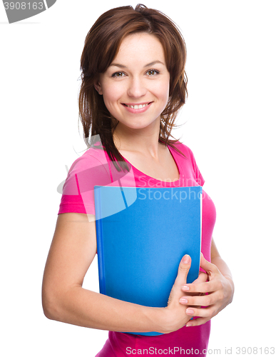 Image of Young skinny student girl is holding exercise book