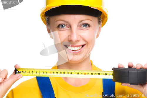 Image of Young construction worker with tape measure