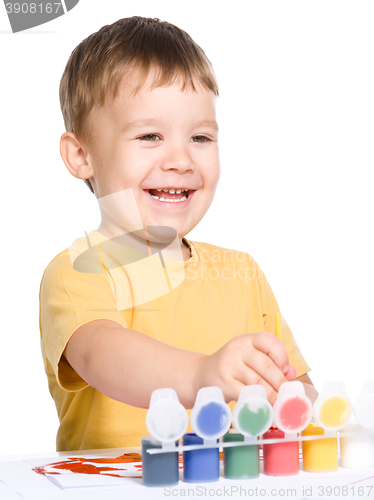 Image of Little boy is playing with paints