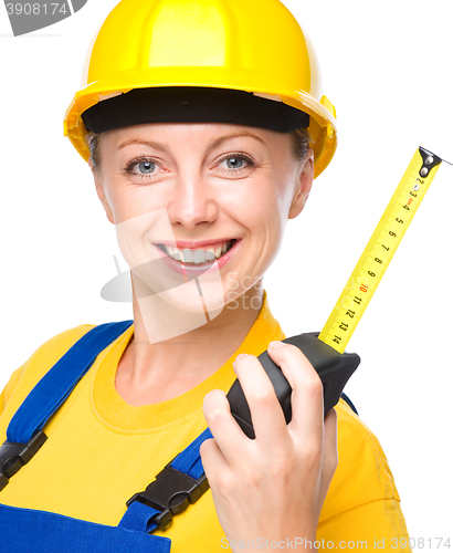 Image of Young construction worker with tape measure