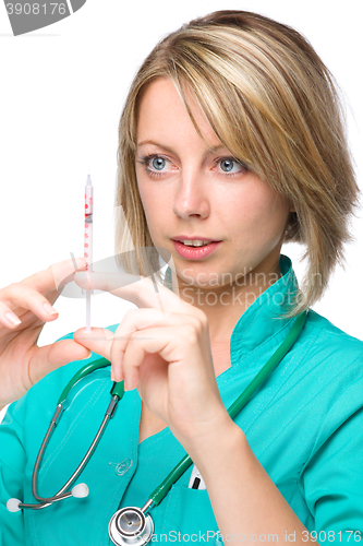 Image of Young nurse is preparing syringe for injection