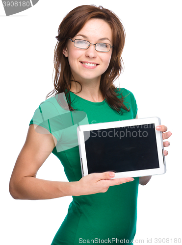 Image of Young cheerful woman is showing blank tablet