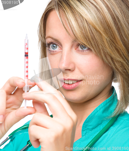 Image of Young nurse is preparing syringe for injection