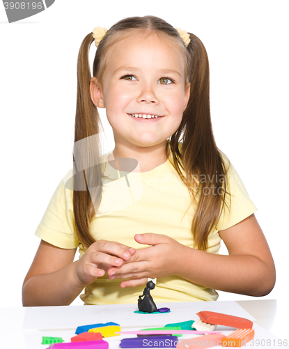 Image of Little girl is playing with plasticine