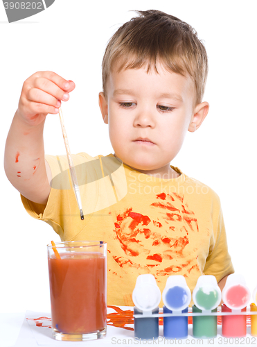 Image of Little boy is playing with paints