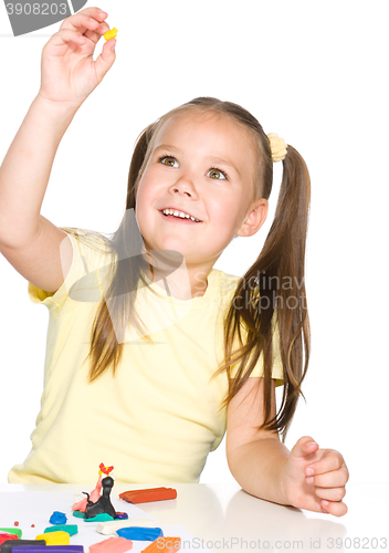 Image of Little girl is playing with plasticine