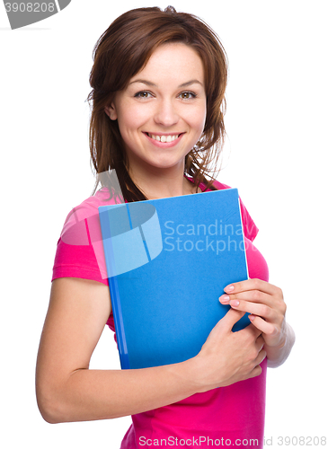 Image of Young skinny student girl is holding exercise book