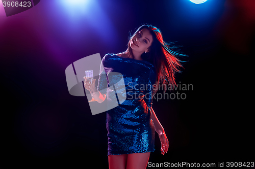 Image of The beautiful girl dancing at the party drinking champagne