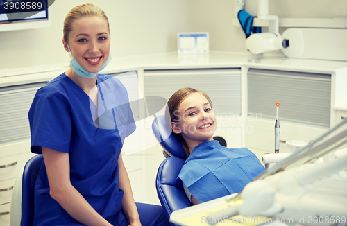 Image of happy female dentist with patient girl at clinic