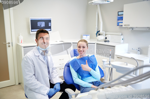 Image of happy male dentist with woman patient at clinic