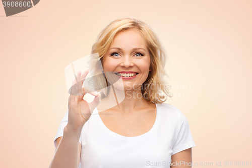 Image of happy woman in white t-shirt showing ok hand sign