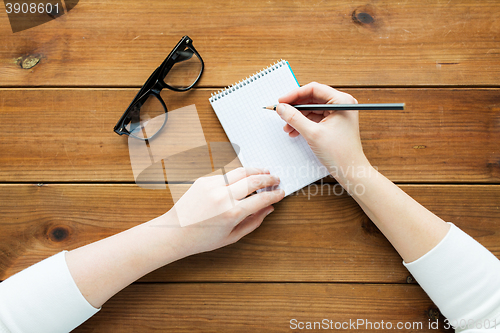 Image of close up of woman or student writing to notepad
