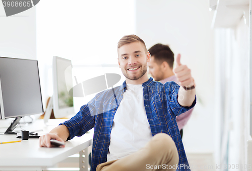 Image of happy creative man with computer at office