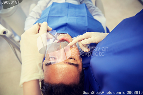 Image of close up of dentist checking male patient teeth