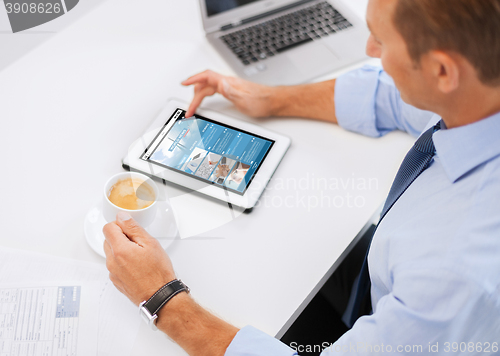 Image of businessman with tablet pc and coffee in office