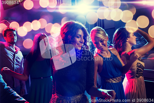 Image of smiling friends dancing in club