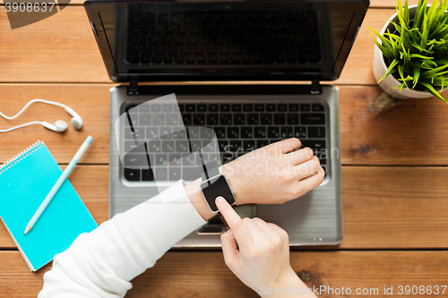 Image of close up of woman with smart watch and laptop