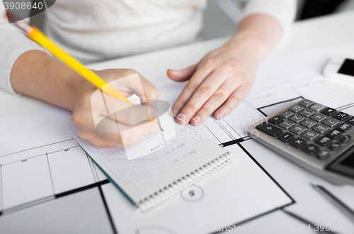 Image of close up of architect hand writing to notebook