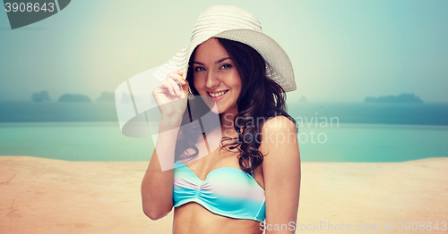 Image of happy young woman in bikini swimsuit and sun hat