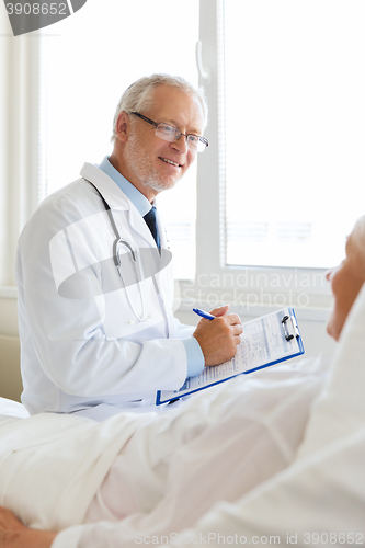 Image of senior woman and doctor with clipboard at hospital