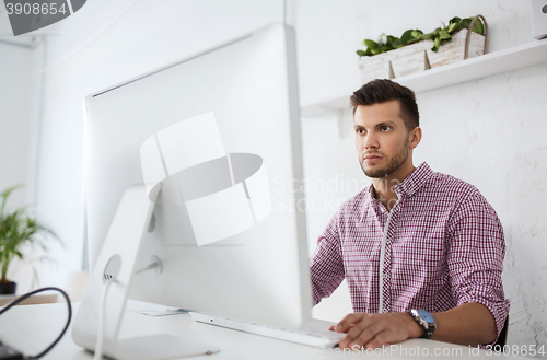 Image of creative man or student with computer at office