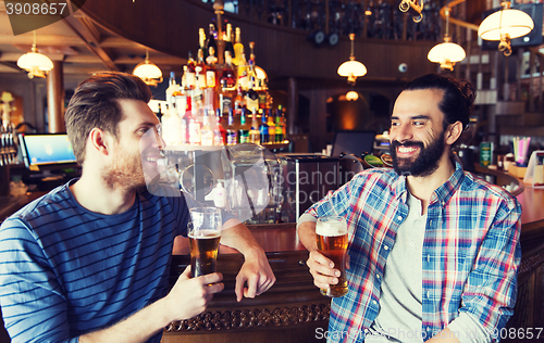 Image of happy male friends drinking beer at bar or pub