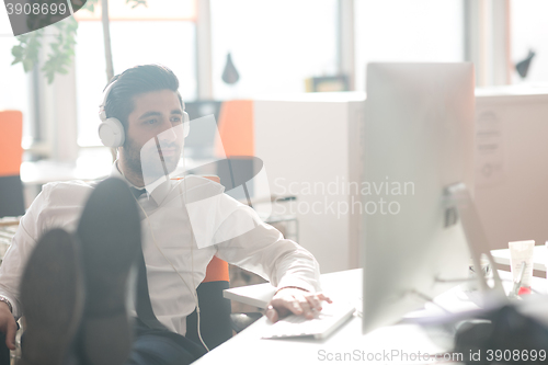 Image of relaxed young business man at office