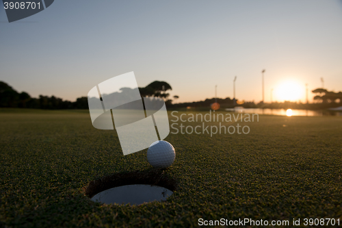 Image of golf ball on edge of  the hole