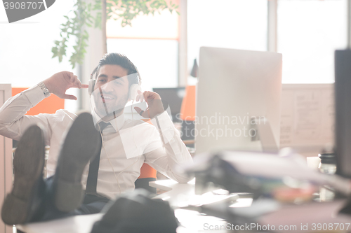 Image of relaxed young business man at office