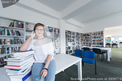 Image of female student study in library, using tablet and searching for 