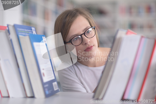 Image of portrait of famale student selecting book to read in library