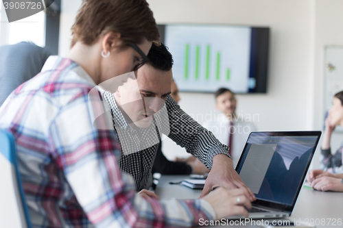 Image of young business couple working on laptop, businesspeople group on