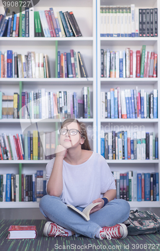 Image of famale student reading book in library