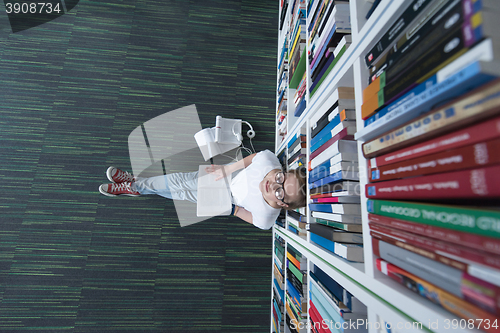 Image of female student study in library, using tablet and searching for 