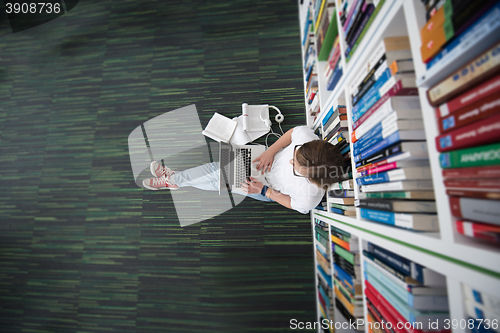 Image of female student study in library, using tablet and searching for 