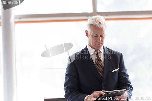 Image of senior business man working on tablet computer