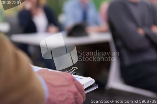 Image of Closeup of mature hands holding tablet.