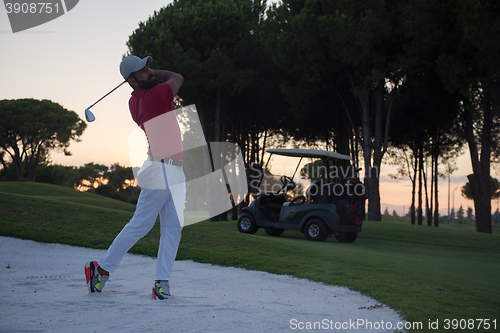 Image of golfer hitting a sand bunker shot on sunset