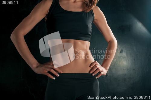 Image of Muscular young woman athlete on black