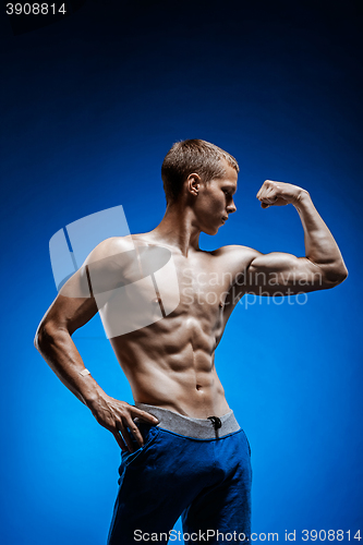 Image of Fit young man with beautiful torso on blue background