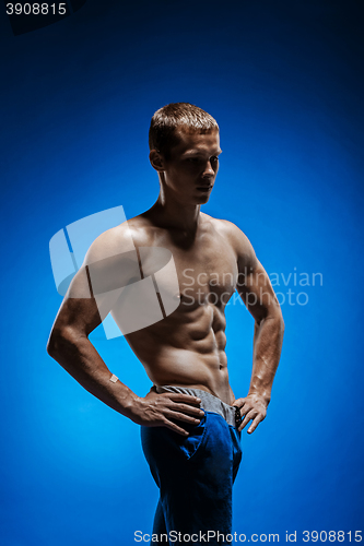 Image of Fit young man with beautiful torso on blue background