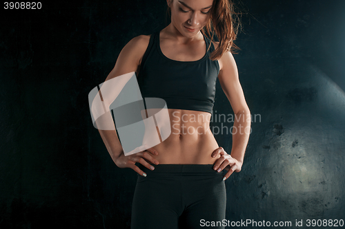 Image of Muscular young woman athlete on black