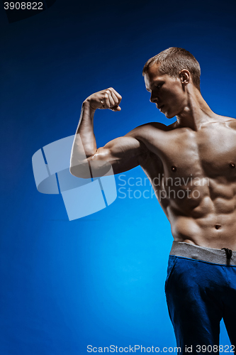 Image of Fit young man with beautiful torso on blue background