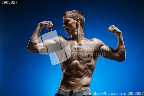 Image of Fit young man with beautiful torso on blue background