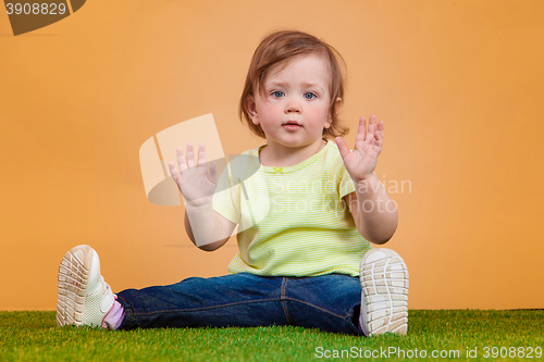Image of One cute baby girl on orange background