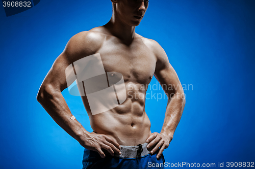 Image of Fit young man with beautiful torso on blue background