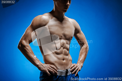 Image of Fit young man with beautiful torso on blue background