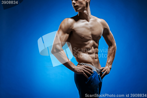 Image of Fit young man with beautiful torso on blue background