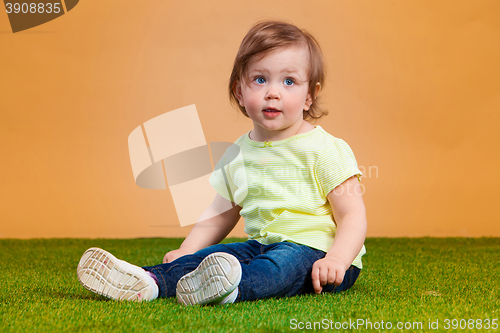 Image of One cute baby girl on orange background