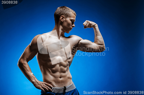 Image of Fit young man with beautiful torso on blue background